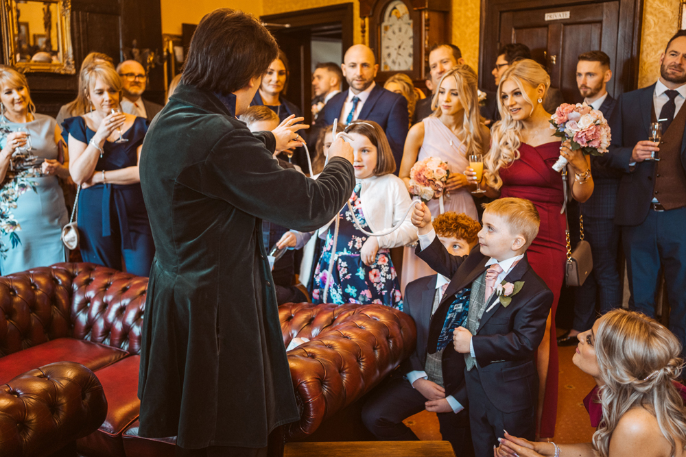 Guests at a wedding being entertained by a magician